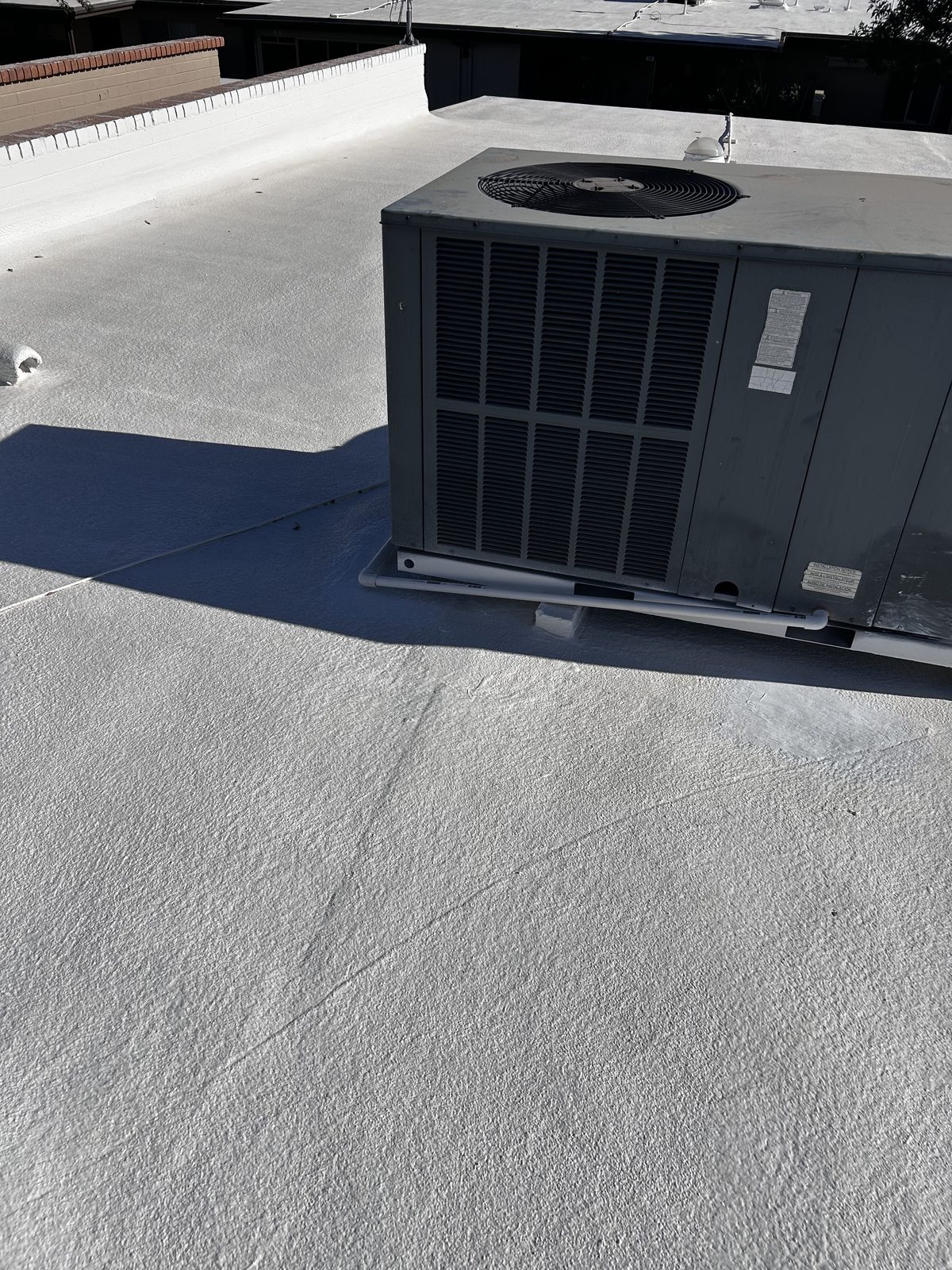 CS11 6 After photo of new white elastomeric coating hand detailed around a rooftop AC unit on the restored Mesa roof