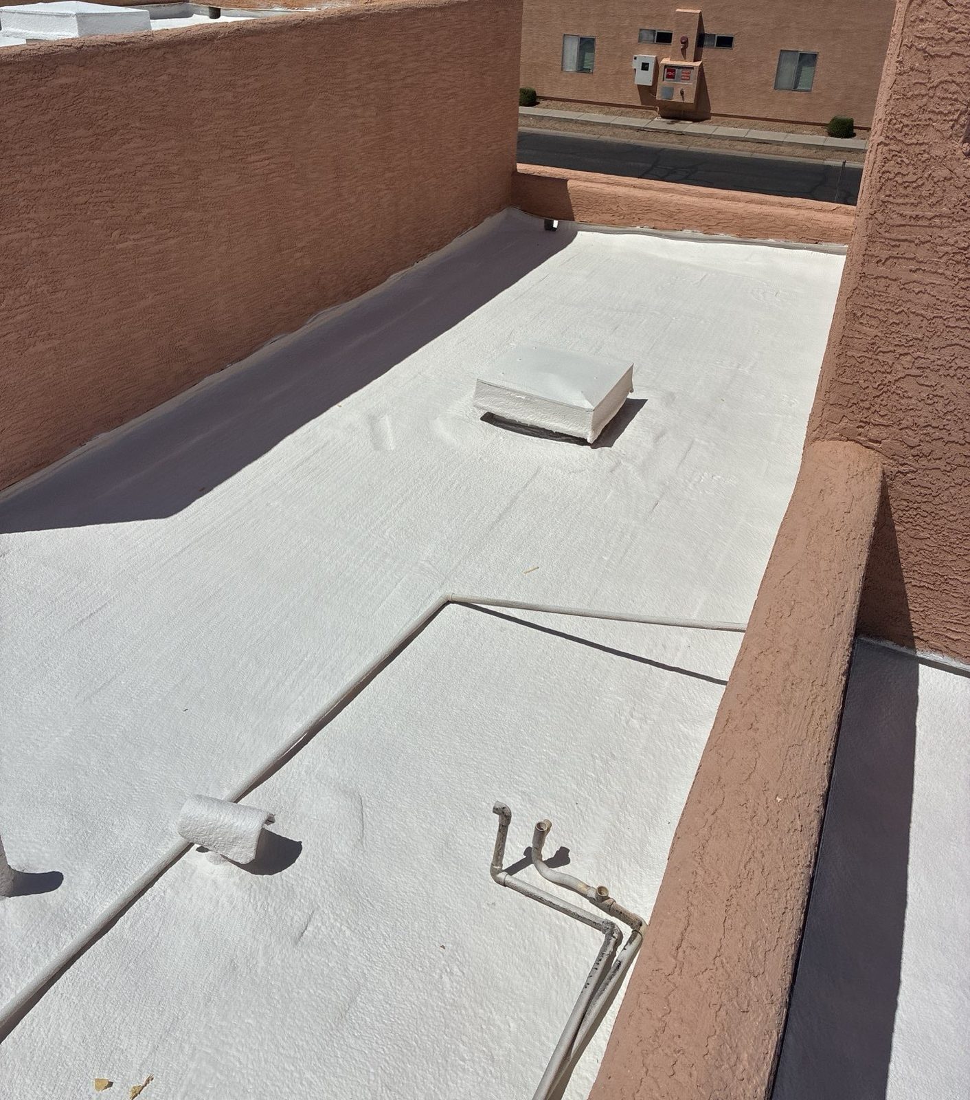 CS12 7 After photo of a finished Peoria roof section with a clean white elastomeric surface and detailed parapet walls