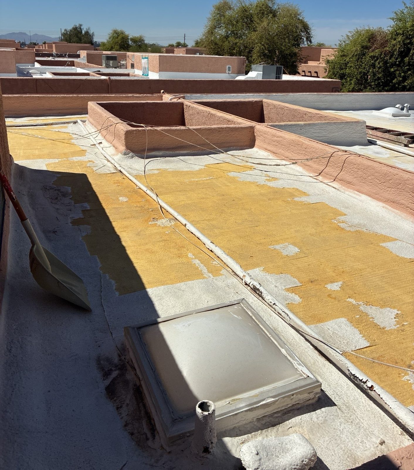 Before photo of a Peoria commercial foam roof with the coating worn away, exposing oxidized yellow polyurethane foam