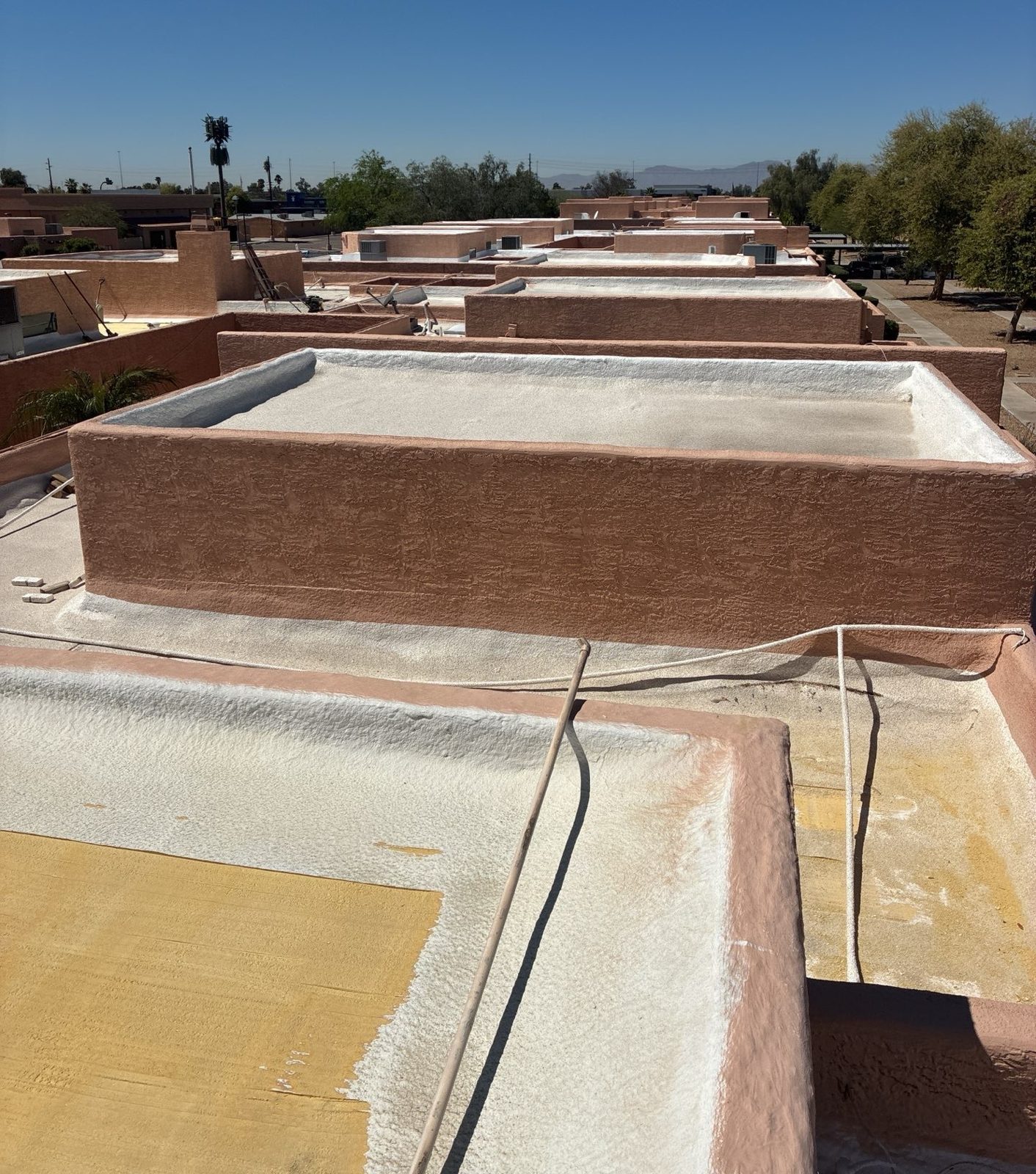 CS12 6 Before photo of Peoria roof sections showing exposed oxidized foam alongside areas already prepared for the new system