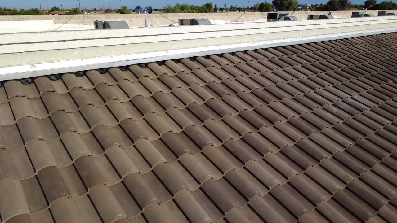 After photo of the same Glendale retail roof with new brown Eagle Capistrano concrete tile running up to a coated parapet wall