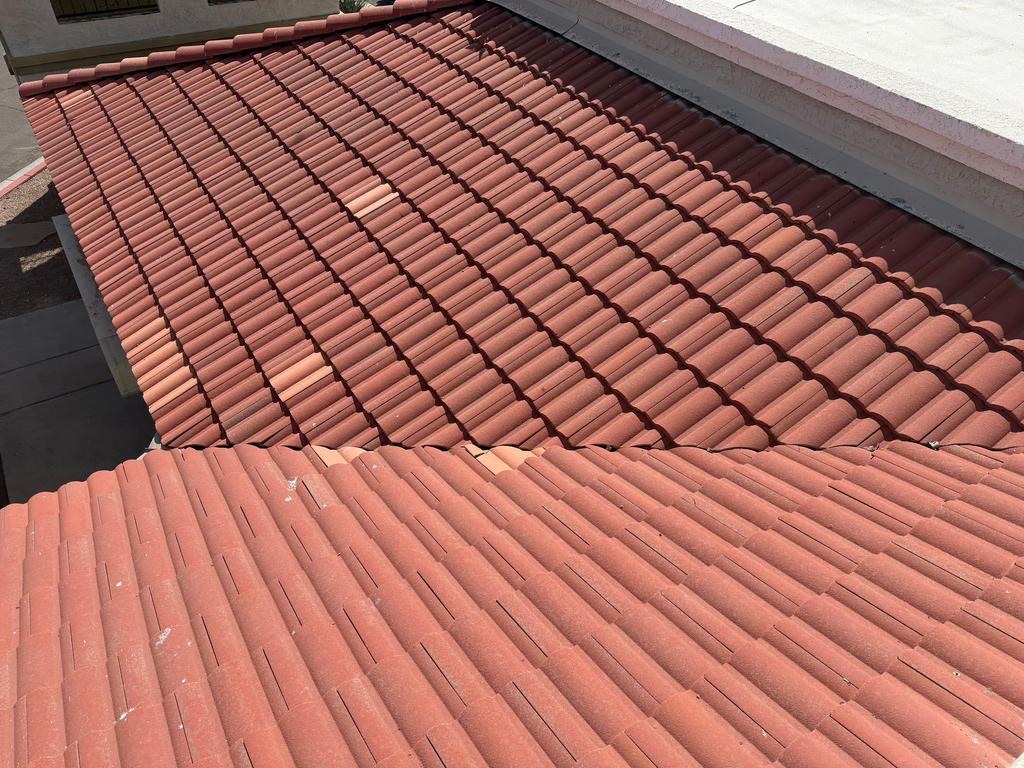 Before photo of a faded salmon concrete tile roof on a Glendale retail center with mismatched replacement tiles from earlier spot repairs