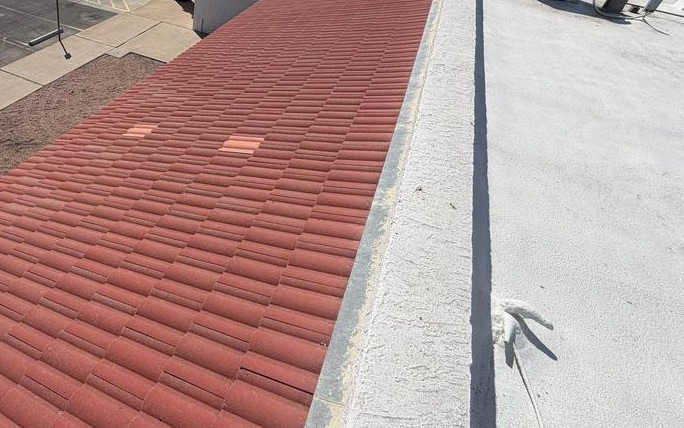 CS13 6 Before photo of a long faded salmon tile roof run alongside the white flat roof and parapet of a Glendale retail center