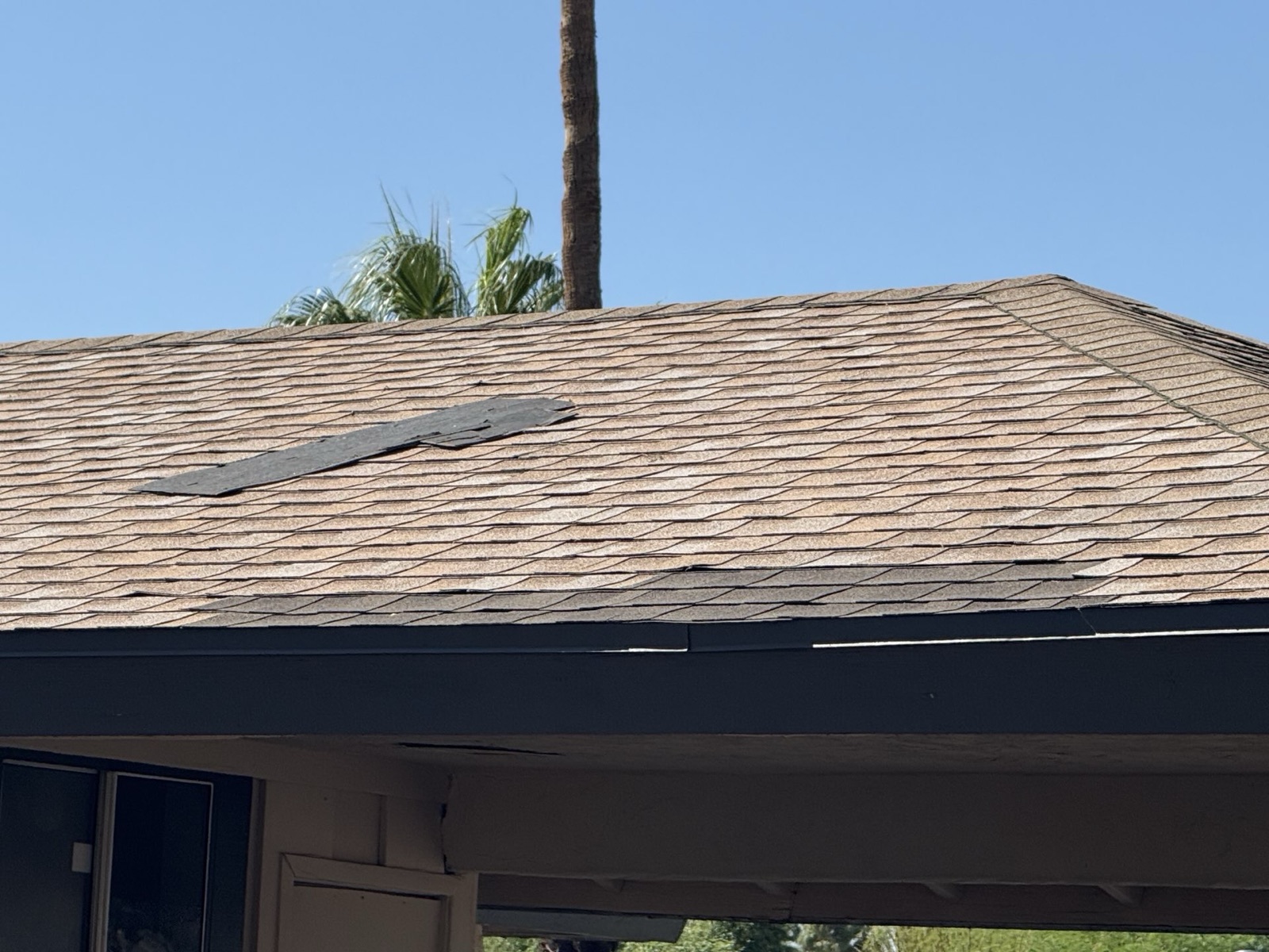 CS14 6 Before photo of a faded, granule-worn shingle roof with a mismatched dark shingle patch running across the slope