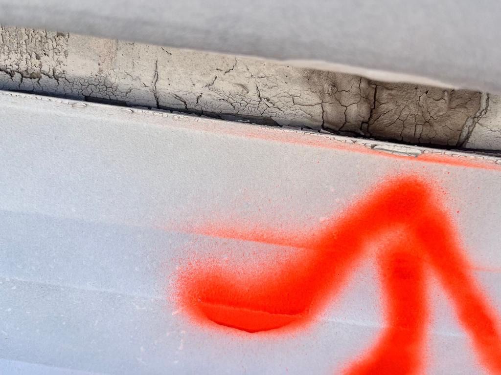 CS15 6 Before photo of cracked and crazed sealant failing along a termination detail above the TPO membrane, with inspection marking paint applied below it