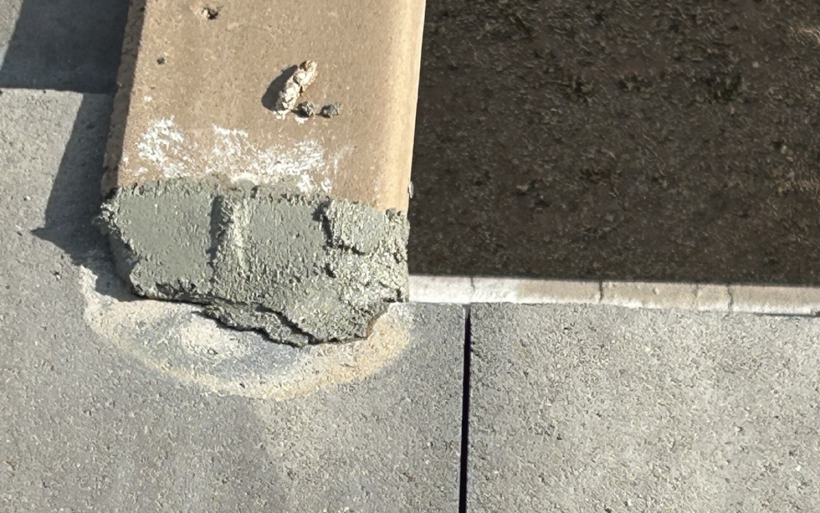 CS16 7 After photo of fresh mortar packed under a rake tile on the Tempe roof with the flat tiles re-set in line below it