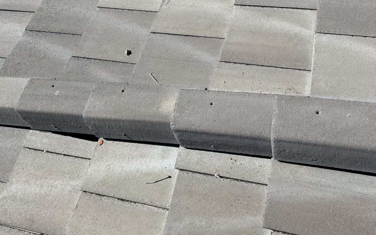 CS16 6 Before photo of Tempe concrete roof tiles shifted out of their courses at a hip, with loose nails sitting on the tile surface