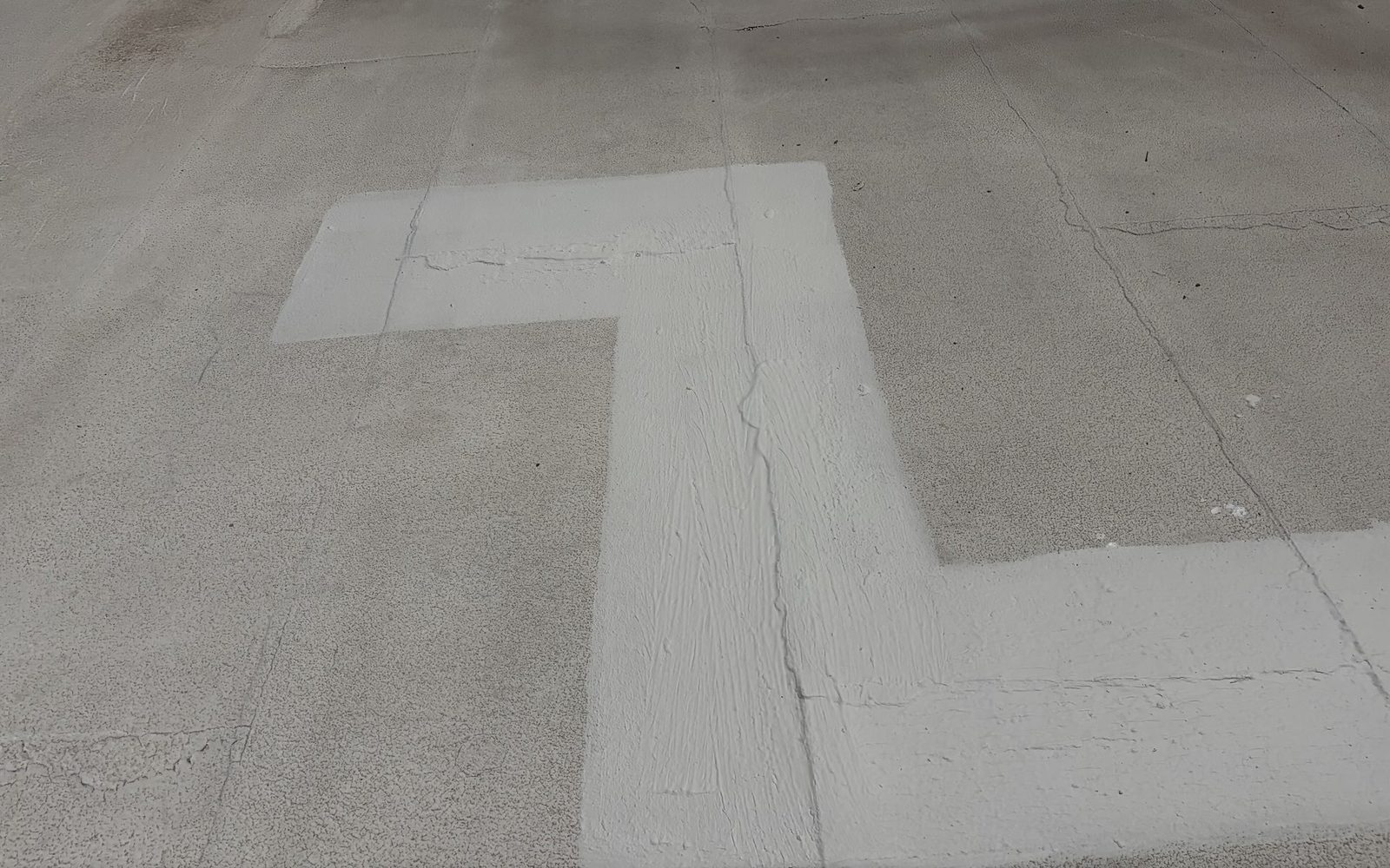 After photo of the same style of roof seam sealed with fresh white elastomeric coating on a cleaned roof surface