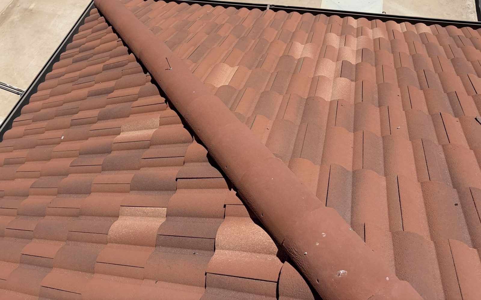 CS17 7 After photo of the same tile roof section with replacement tiles set in, shifted tiles reseated, an intact hip ridge, and the debris cleared