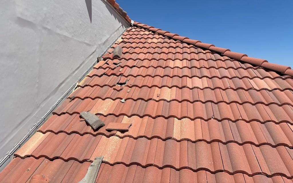 CS17 6 Before photo of a Scottsdale retail center tile roof section with broken tile fragments lying loose on the field and shifted tiles