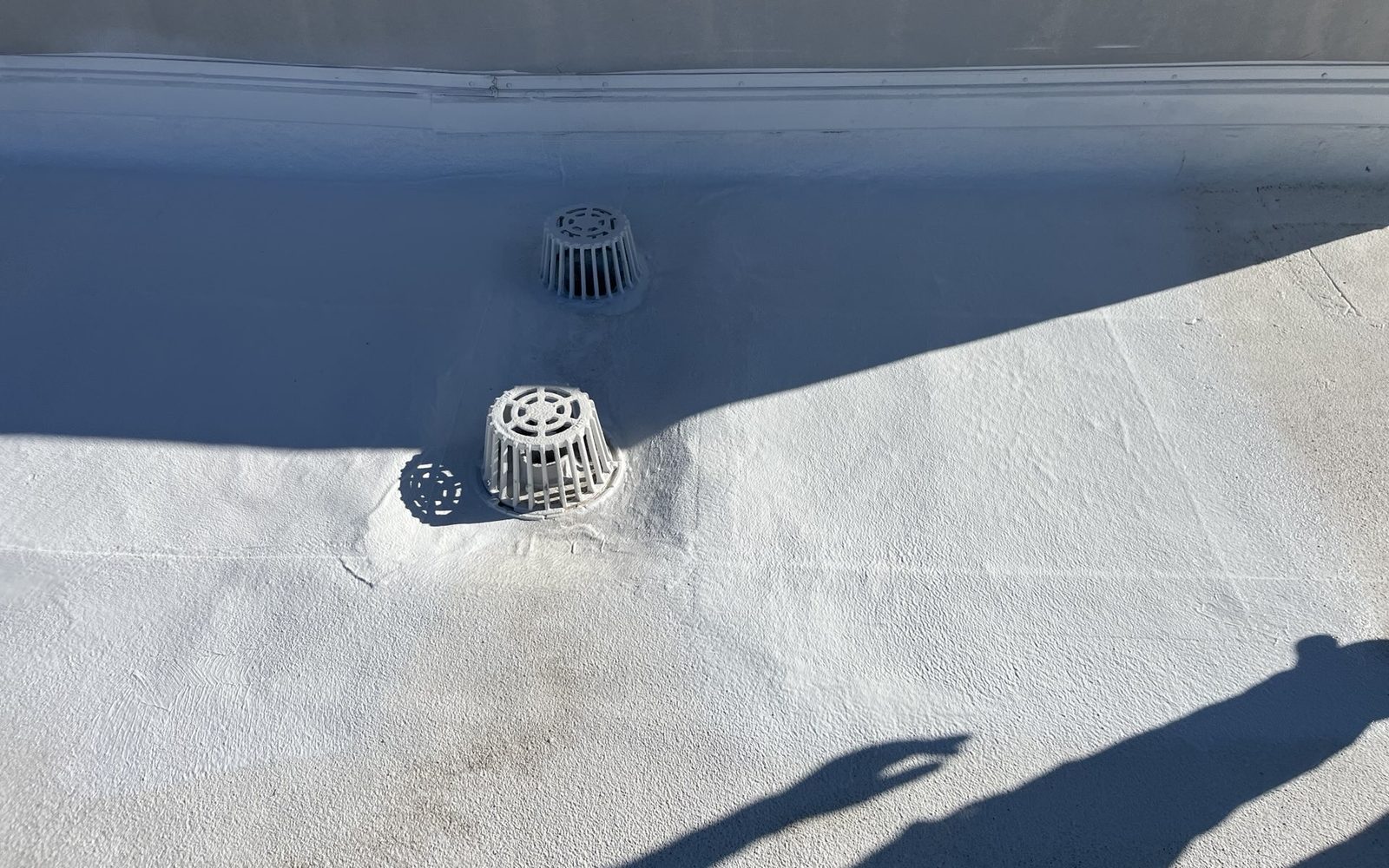 CS18 7 After photo of restored roof drains on the Phoenix cap sheet roof, with reinforcing fabric embedded and coated into a clean white acrylic surface