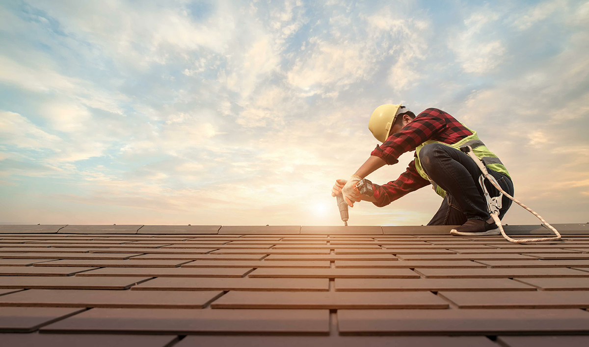 Roofer Working In Special Protective Work Wear Gloves, Using Air