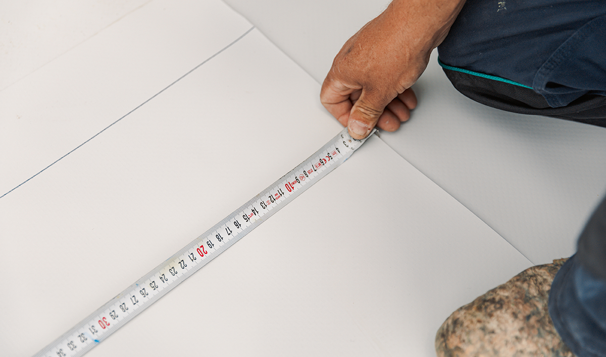 Worker Measures With Roulette Pvc Membrane To Be Cut