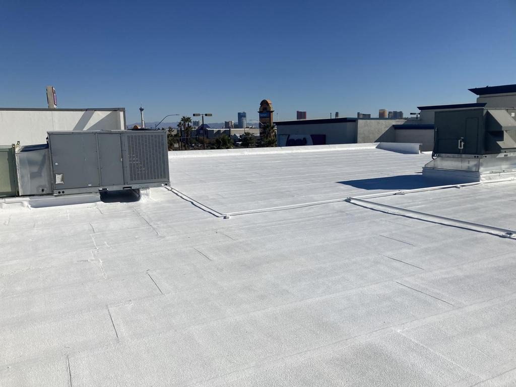 After photo of the completed white elastomeric roof coating in Las Vegas with the city skyline in the background