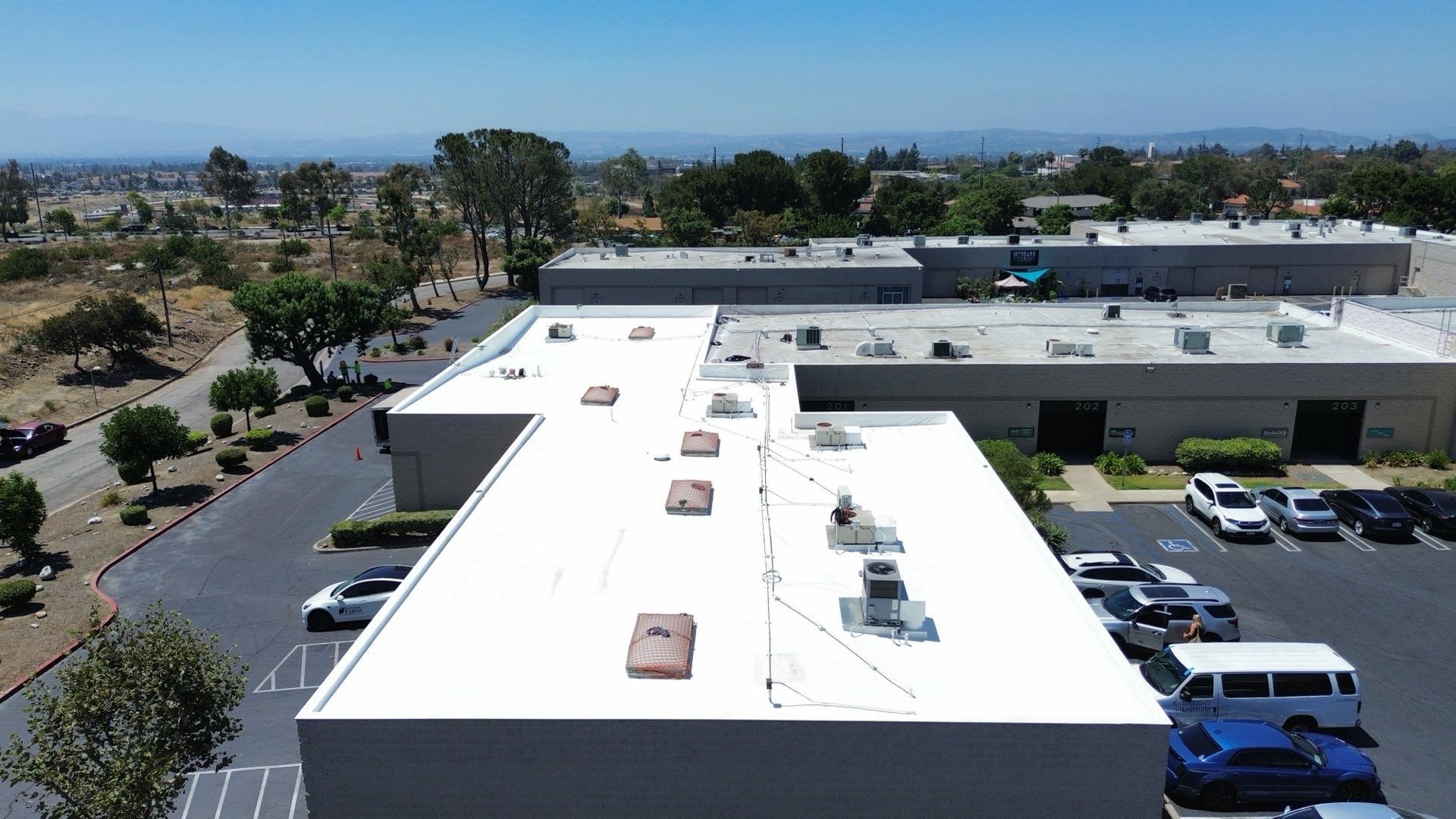 Aerial after photo showing the freshly applied white elastomeric coating on the Claremont commercial roof