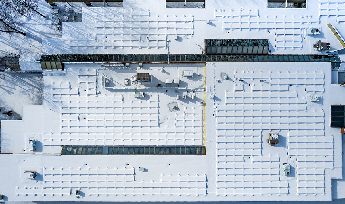 Snow Covered Solar Panels On Commercial Roof