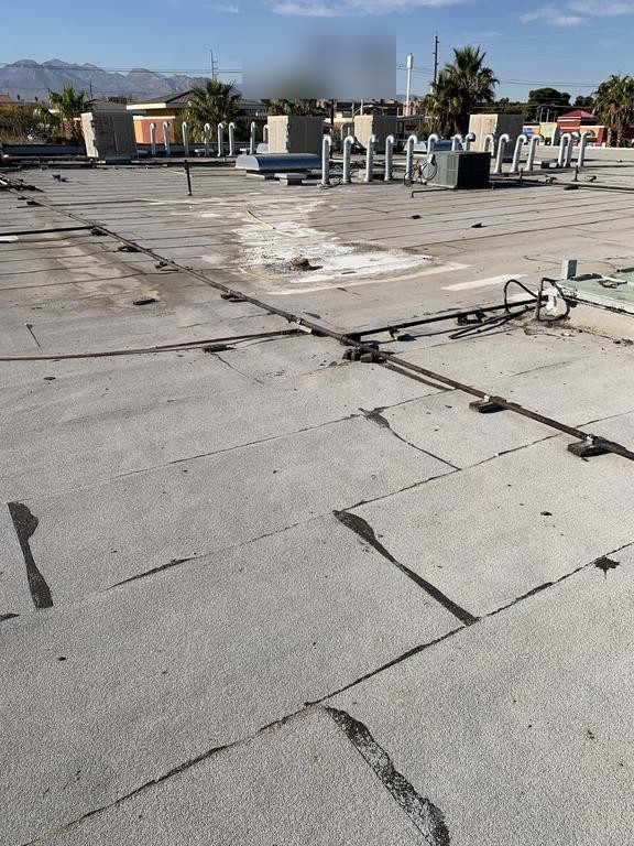 Before photo of an aging cap sheet roof in Las Vegas with cracked seams prior to recoating