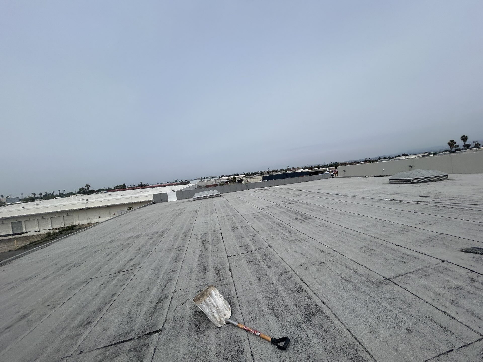 Before photo of an aging built-up roof on a Santa Ana warehouse prior to recoating