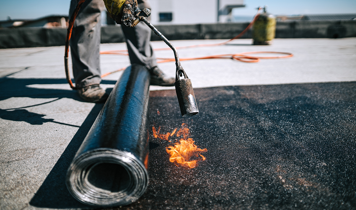 Professional Workers Insulating Rooftop With Bitumen Membrane W